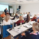 Seminarteilnehmer in Vortragssituation mit Referent