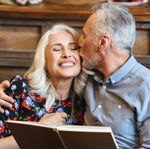 Älteres Paar, der Mann küsst die Frau auf die Wange