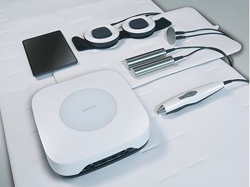 Sanza-Geräteset mit Steuergerät, Applikatoren und Zubehör neatly ausgelegt auf einer Therapieliege